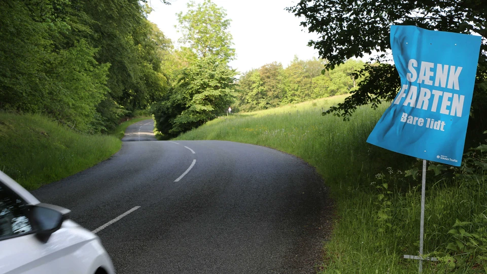 Bil på vejen ved vejskilt