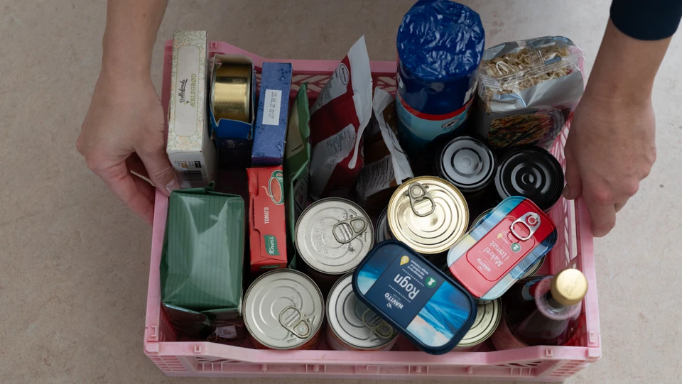 En kurv fuld af langtidsholdbar mad i dåser, poser og pakker.