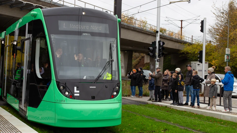 Letbane kører ind på stationen, chauffør vinker i vinduet