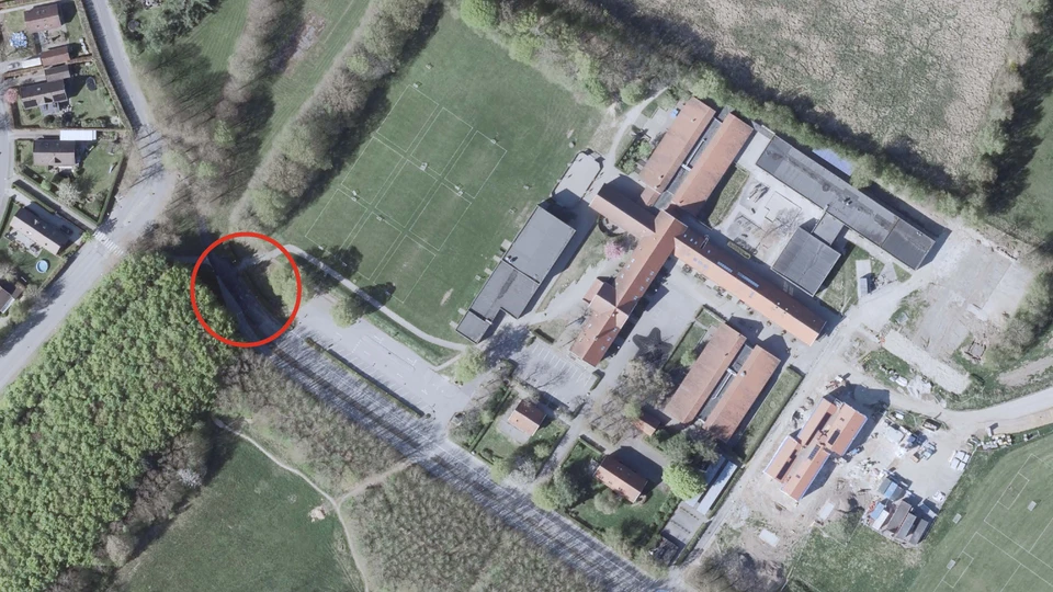 Luftfoto over Vallensbæk Skole og en markering mellem skoven og fodboldbanerne, der vender mod nord og landsbyen.