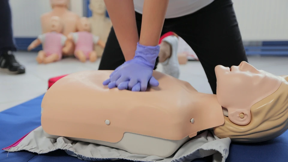 En dukketorso, hvor en person er ved at udføre hjertemassage på.